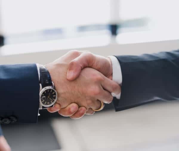 Two men are shaking hands together.
