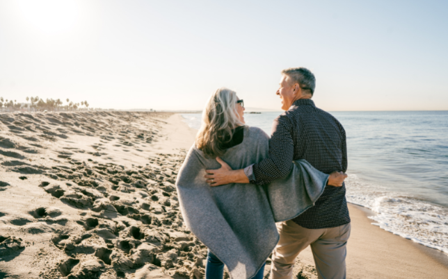 A couple, man and woman walking a longside the beach