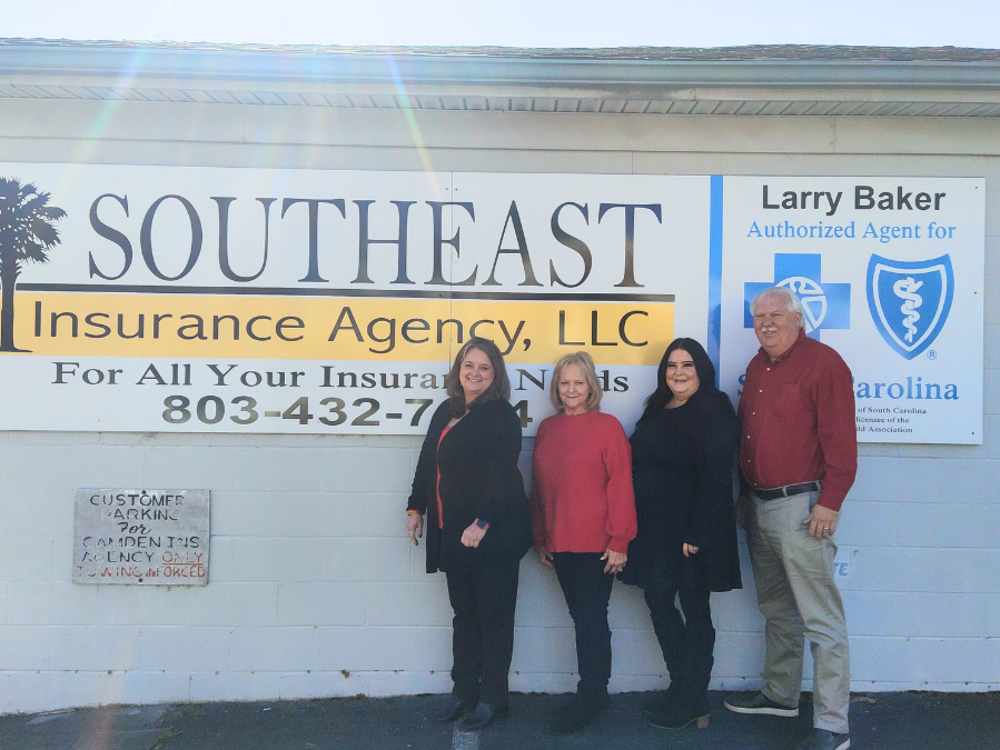 Employees of Southeast Insurance Agency stand in front of the company sign